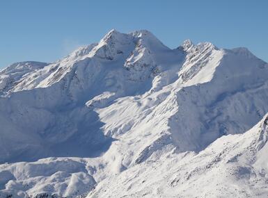 Snow-covered mountain peaks under a clear blue sky