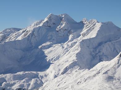 Snow-covered mountain peaks under a clear blue sky