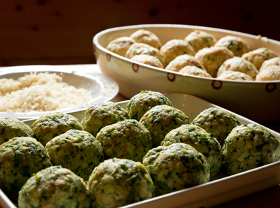 Freshly prepared spinach and cheese dumplings on a tray, ready for cooking.
