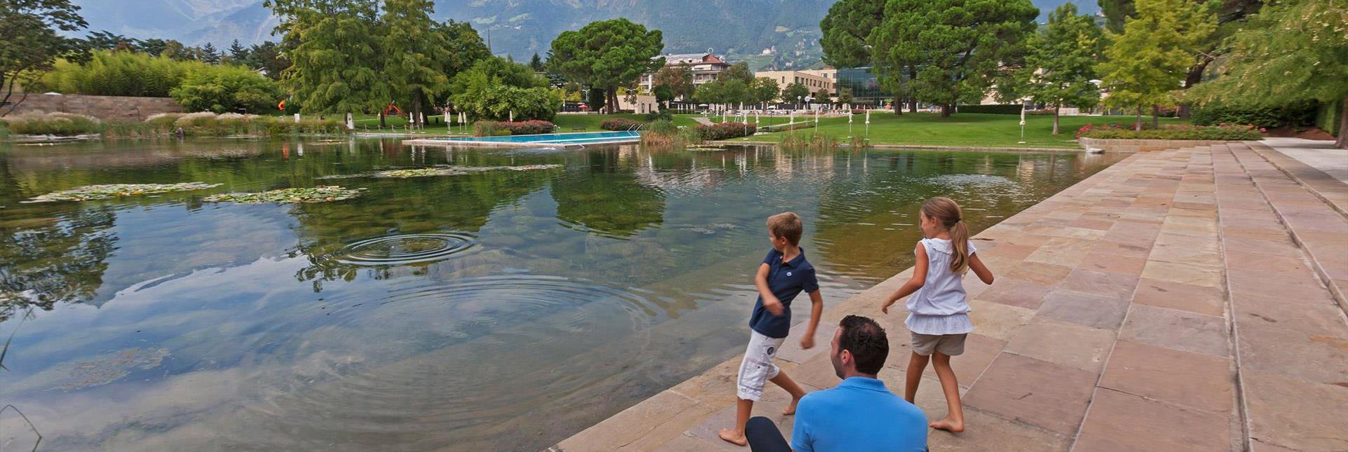 Bambini lanciano sassi in uno stagno