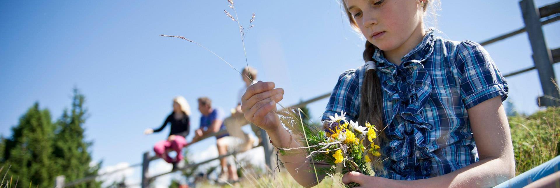 Ein Mädchen pflückt einen Strauß Wildblumen