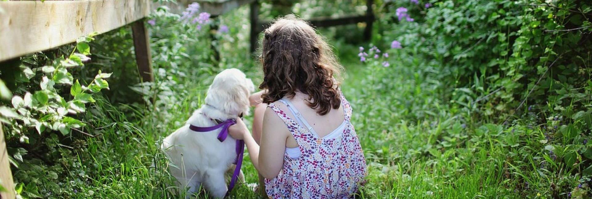 A girl and a dog in a garden
